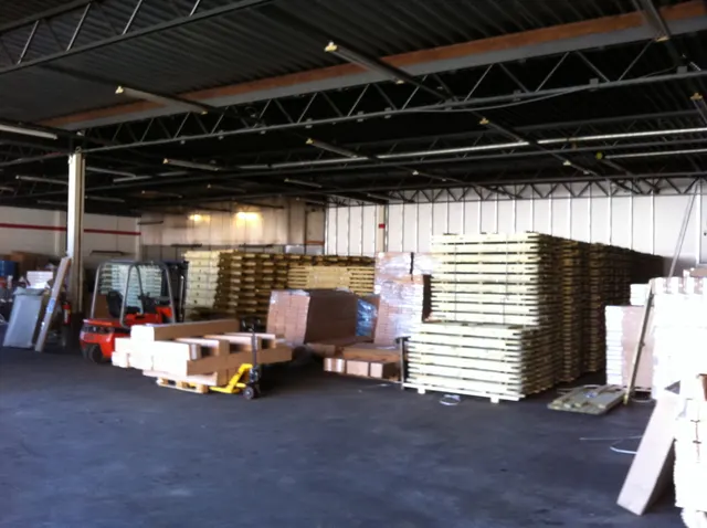 De eerste opslagloods van E-Products Europe in 2012, met stapels houten tafels